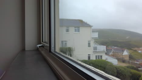 rain flowing down a window with a sea view in slow motion