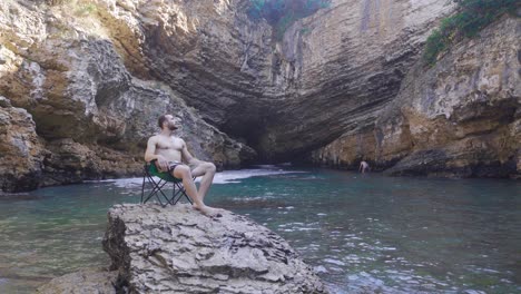 un joven acampando en la playa.