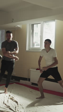 los atletas corren evitando y calentando los brazos en el gimnasio de lucha. los luchadores hacen entrenamiento activo en el club de artes marciales mixtas en cámara lenta. desarrollo corporal
