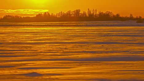 Time-lapse-on-close-up-view-of-the-sun-setting-down-in-the-orange-yellowish-view-with-clouds-moving-background