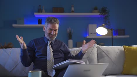 mature businessman happy with good news at home is enjoying himself, he is smiling and happy.