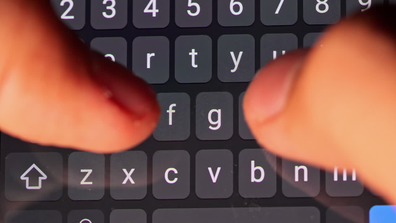 A close-up of hands typing on a smartphone keyboard