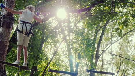 a brave child walks along a tightrope between tall trees active childhood and fun