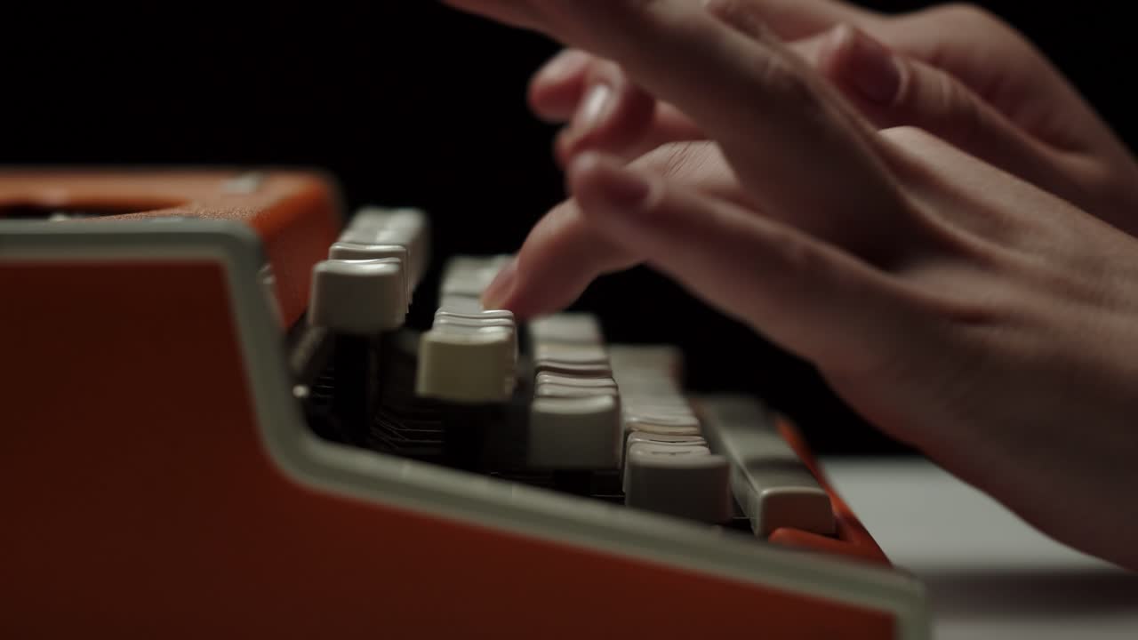 Close-Up of Hands Typing on a Vintage Orange Typewriter