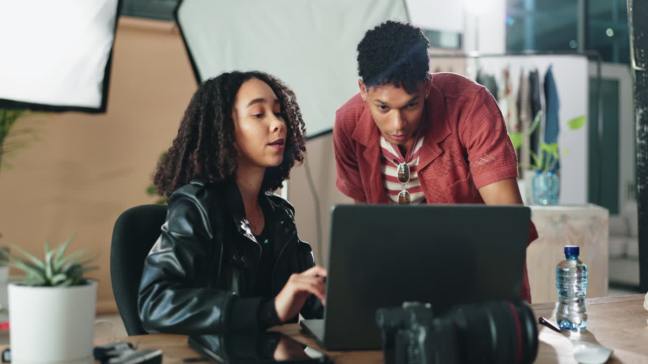 Two young professionals collaborating on a design project in a photography studio.