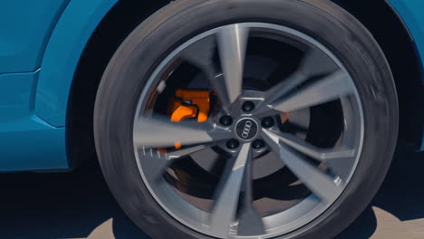 close-up view on the side part of a car and a wheel at moving the road. wheel of luxury white car turning slowly on asphalt road.