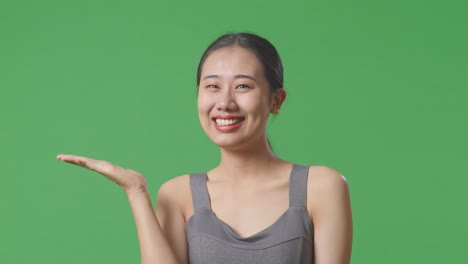 smiling woman presenting on green screen