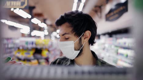 footage from the shelf - man in mask picking milk bottle from the shelf