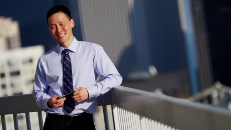 asian male executive using touchscreen technology on rooftop