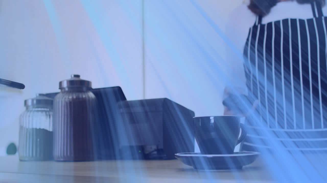 Server steadying terminal as customer tapping phone, blue streaks fading, processing cafe payment