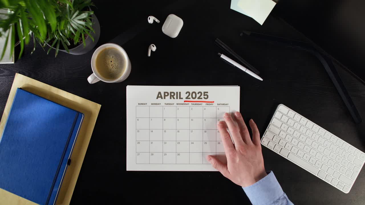 Person Planning for April 2025 on a Desk Calendar