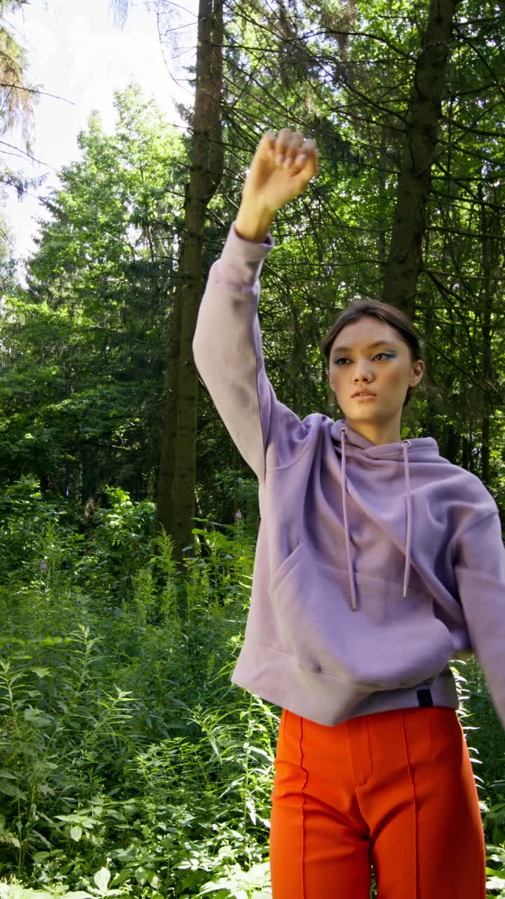 Woman in Purple Hoodie and Orange Pants in Forest