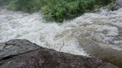 strong water flow on mountain creek stream, fast flowing rapids closeup