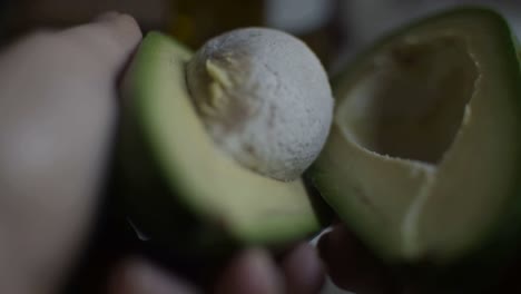 dividing a green avocado in two pieces after cutting it