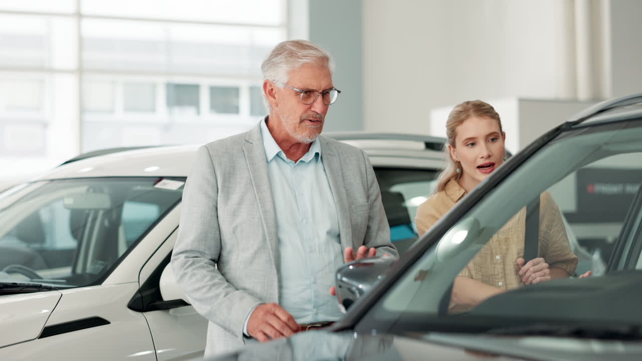 Customers examining cars at a dealership