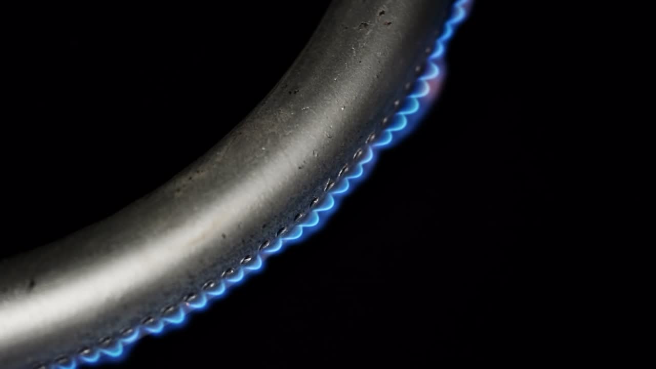 горящий газовый горелку в духовке крупный план на черном фоне. 4k макро сырое видео.