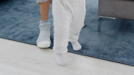 baby learning and walking with support of mother