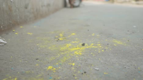 Cerca-De-Los-Pies-Sucios-De-Una-Pobre-Niña-India-De-Piel-Oscura-Que-Se-Aleja,-Polvo-Amarillo-En-Los-Pies-Y-El-Suelo,-Festival-Holi