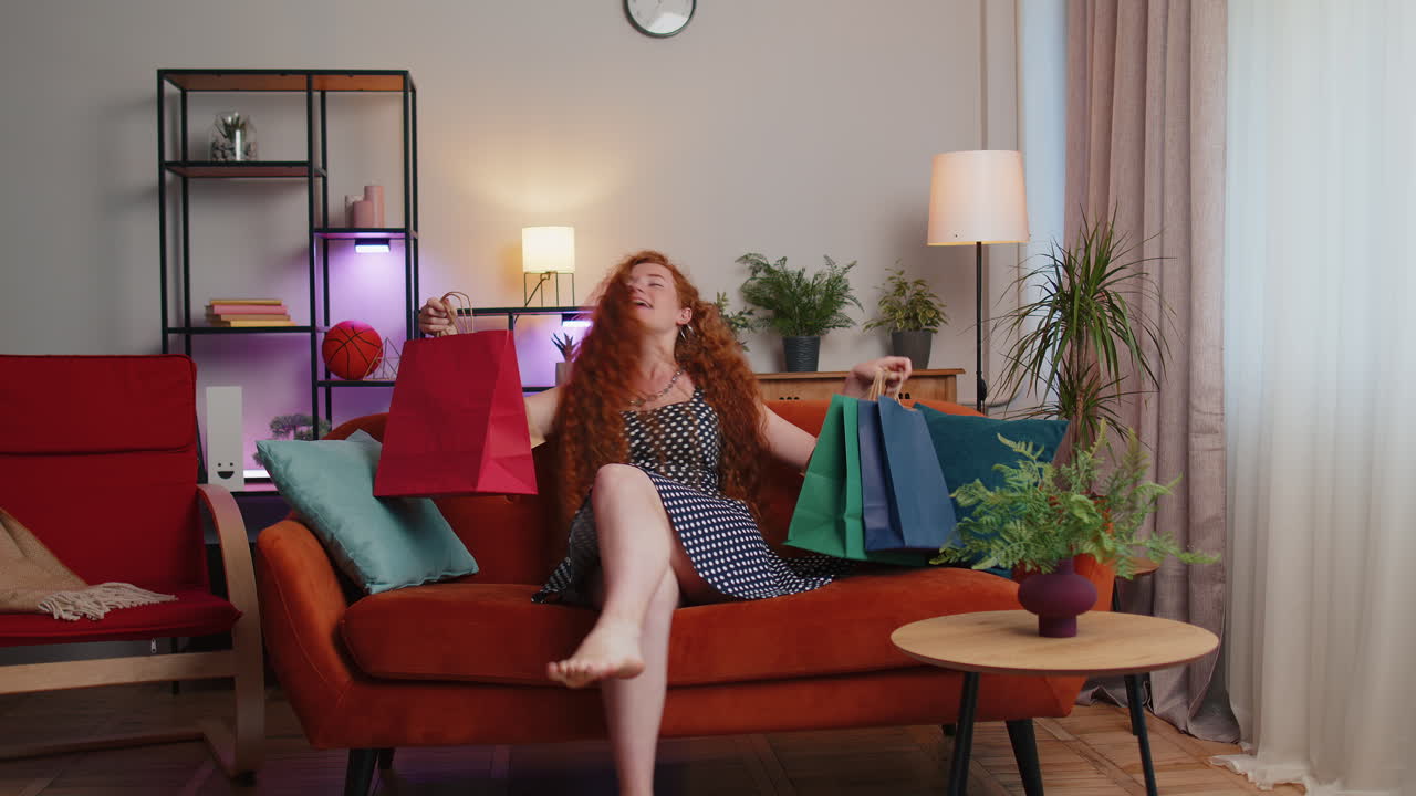 Happy redhead woman shopaholic consumer came back home after online shopping sale with bags at home