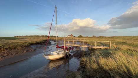 sail boat docked in the estuary with evening golden sunlight