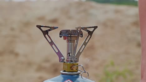 gnition of portable gas stove by woman’s hand with glowing match in slow motion