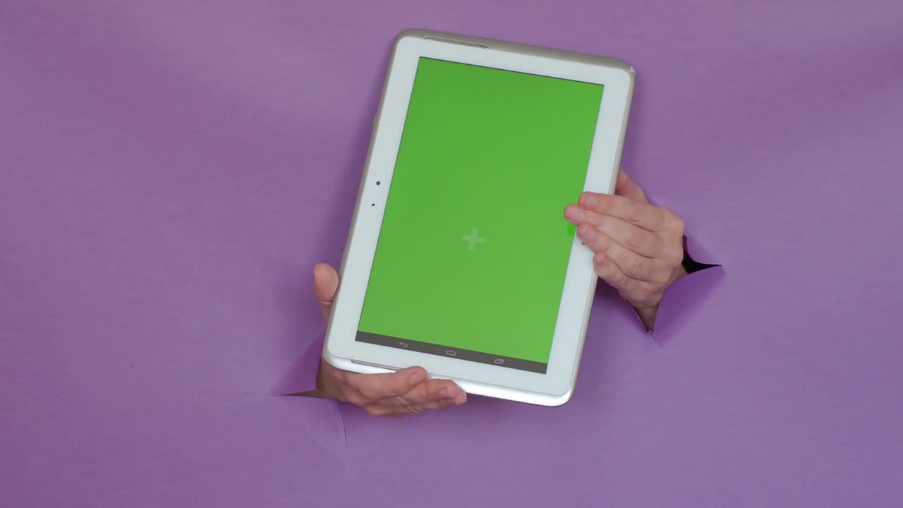 portátil con una pantalla verde en la mano, sobre un fondo púrpura