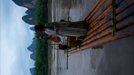 hanfu girl in traditional clothing holds a pipa instrument on a bamboo raft floating on li river, china