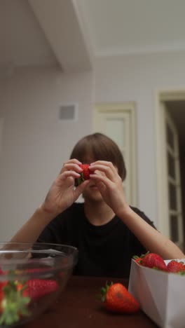 a boy eating strawberries
