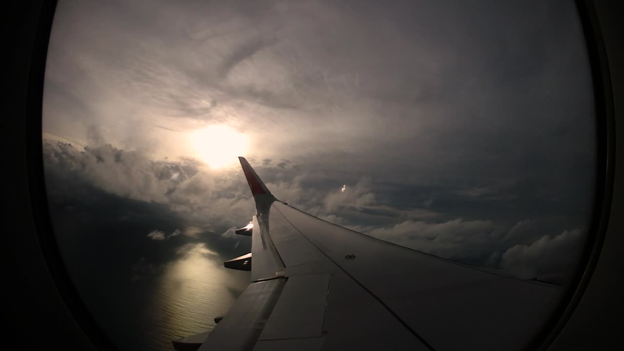 puesta de sol y hermosas nubes desde la ventana del ala izquierda del avión trae recuerdos de viaje