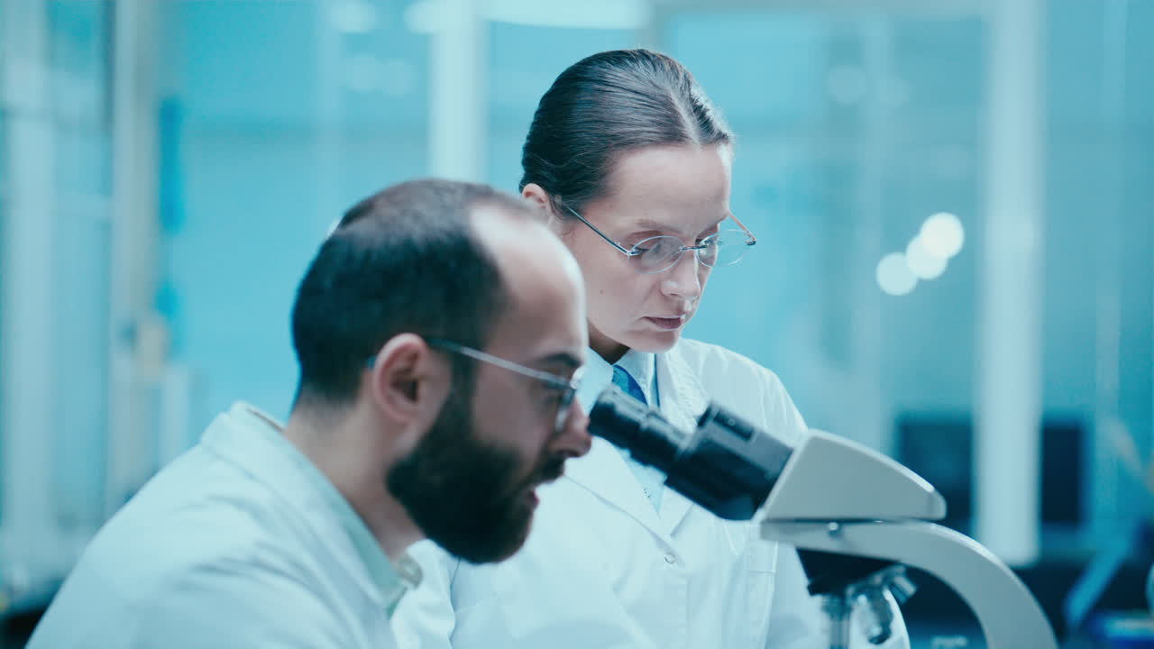 Scienziato di laboratorio che spiega i risultati della ricerca a un collega che prende appunti