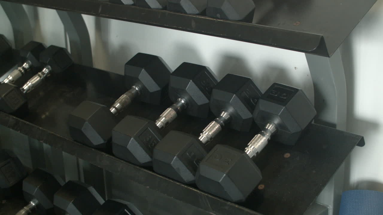 Close Up of a Man Grabbing Dumbbell Weights