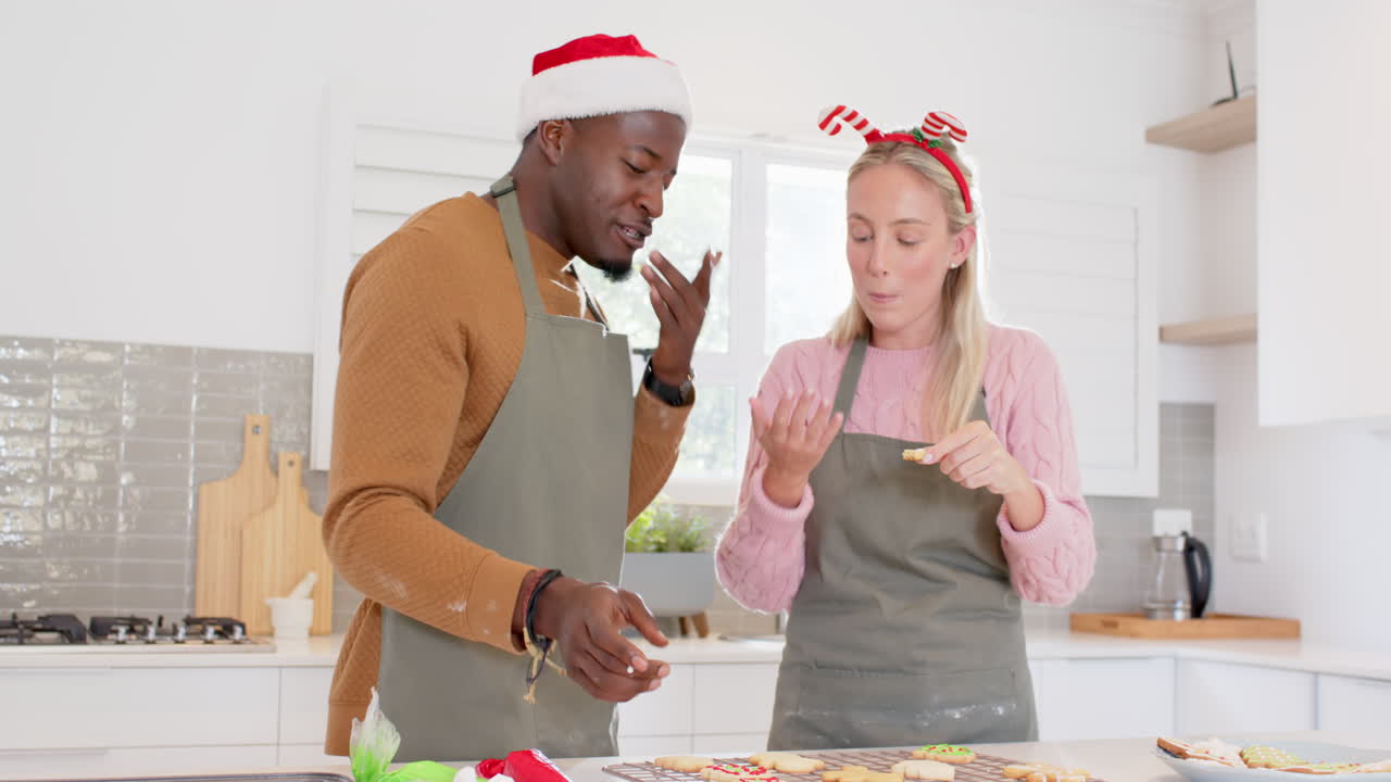 Decorating Christmas cookies, couple baking together in kitchen for festive holiday