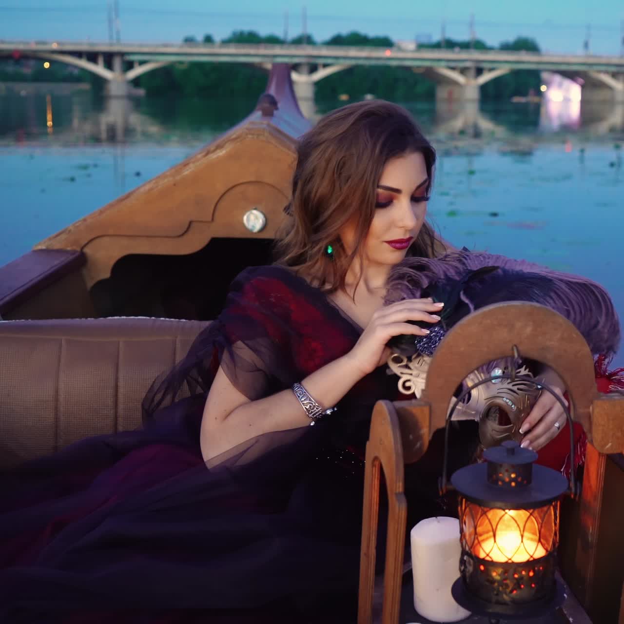 Beautiful woman in a boat. Gondola near the bridge at night.
