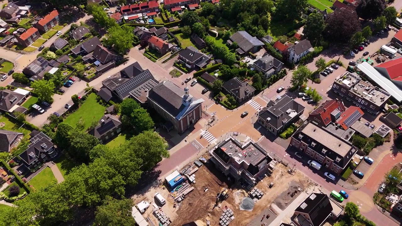 Flygfoto över ett litet torg med en kyrka och en byggarbetsplats