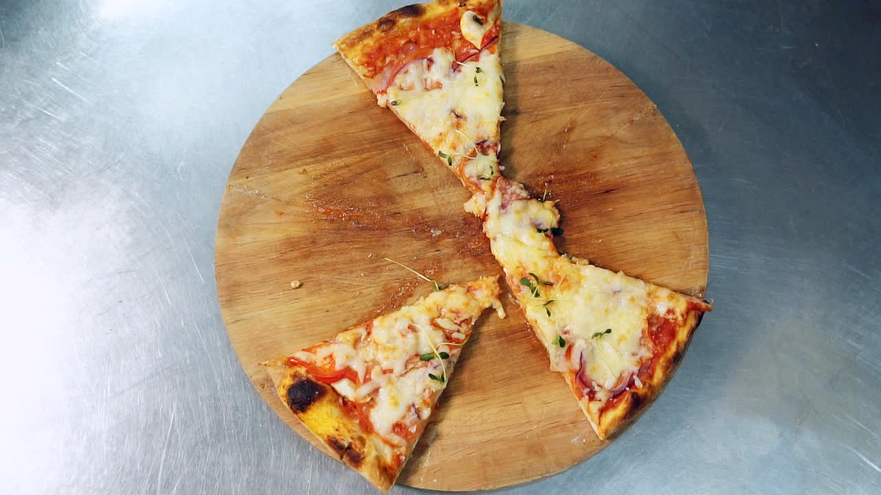Top view male and female hands taking slices of pizza with cheese, tomatoes. Slow motion food video
