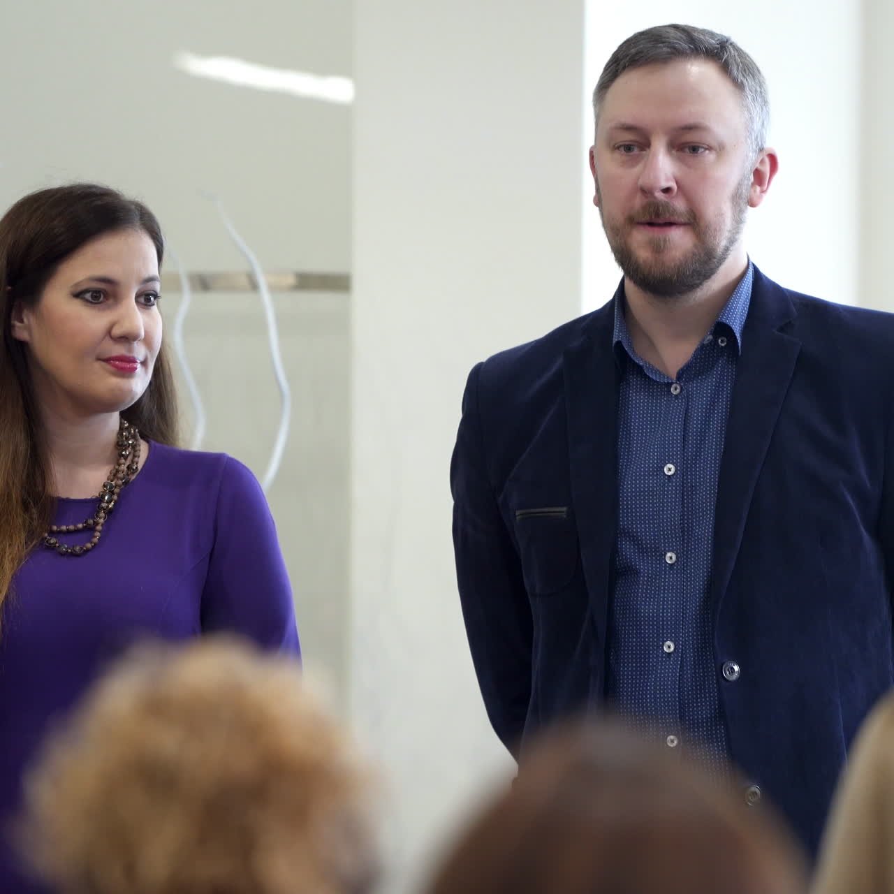 Leaders at business forum. Front view of two entrepreneurs conducting conference in the light auditorium.