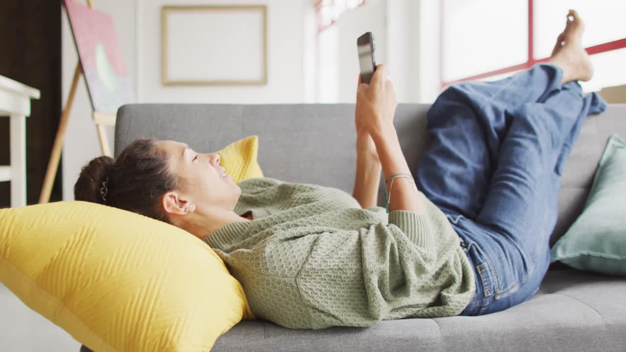 스마트폰을 사용하고 스튜디오에서 휴식을 취하는 행복한 두 인종 여성 디자이너의 비디오