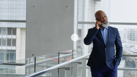 network of digital icons against african american senior businessman talking on smartphone at office