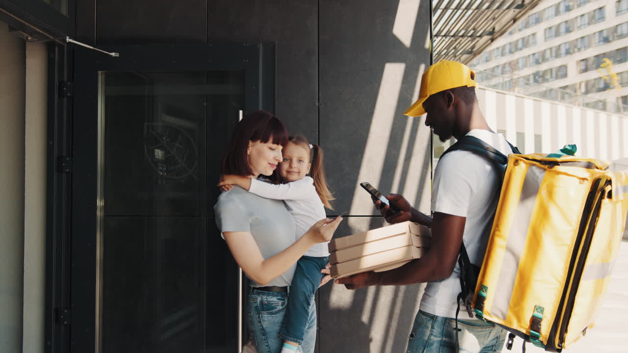 mujer recibiendo una entrega de pizza con su hija