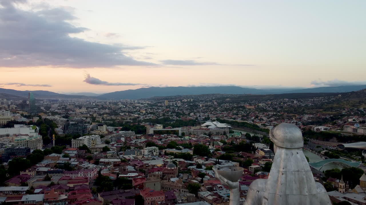 Letecký průlet kolem sochy Matky Gruzie na vrcholu kopce Sololaki s městem Tbilisi dole