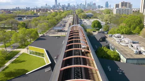 subway train departing modern station, chicago skyline in background