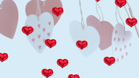 múltiples globos en forma de corazón rojo flotando contra decoraciones en forma de corazón colgantes