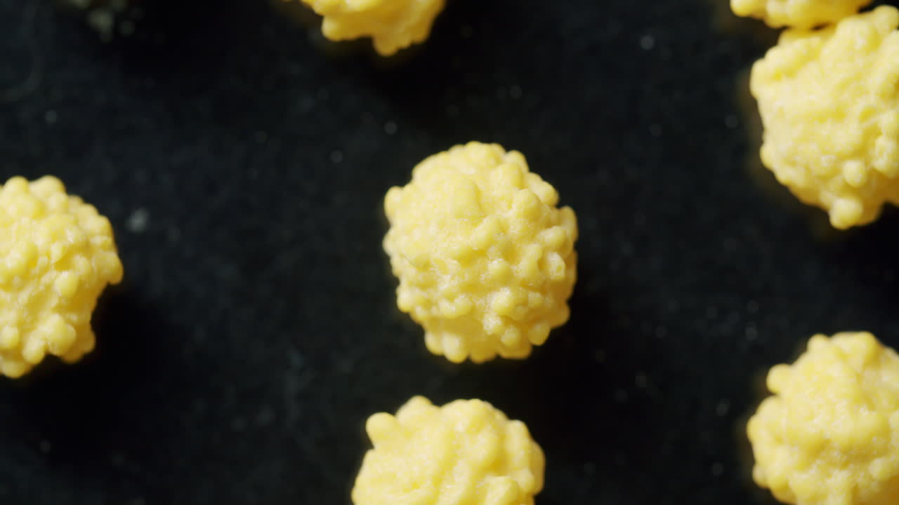 검정색 표면에서 회전하는 노란색 바이러스 세포의 상단 샷