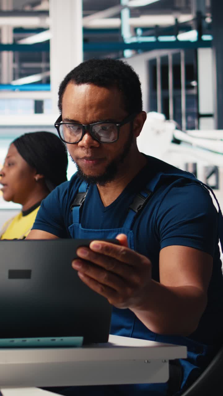 Vertical Video Black engineer inputs solar system parameters at industrial workstation