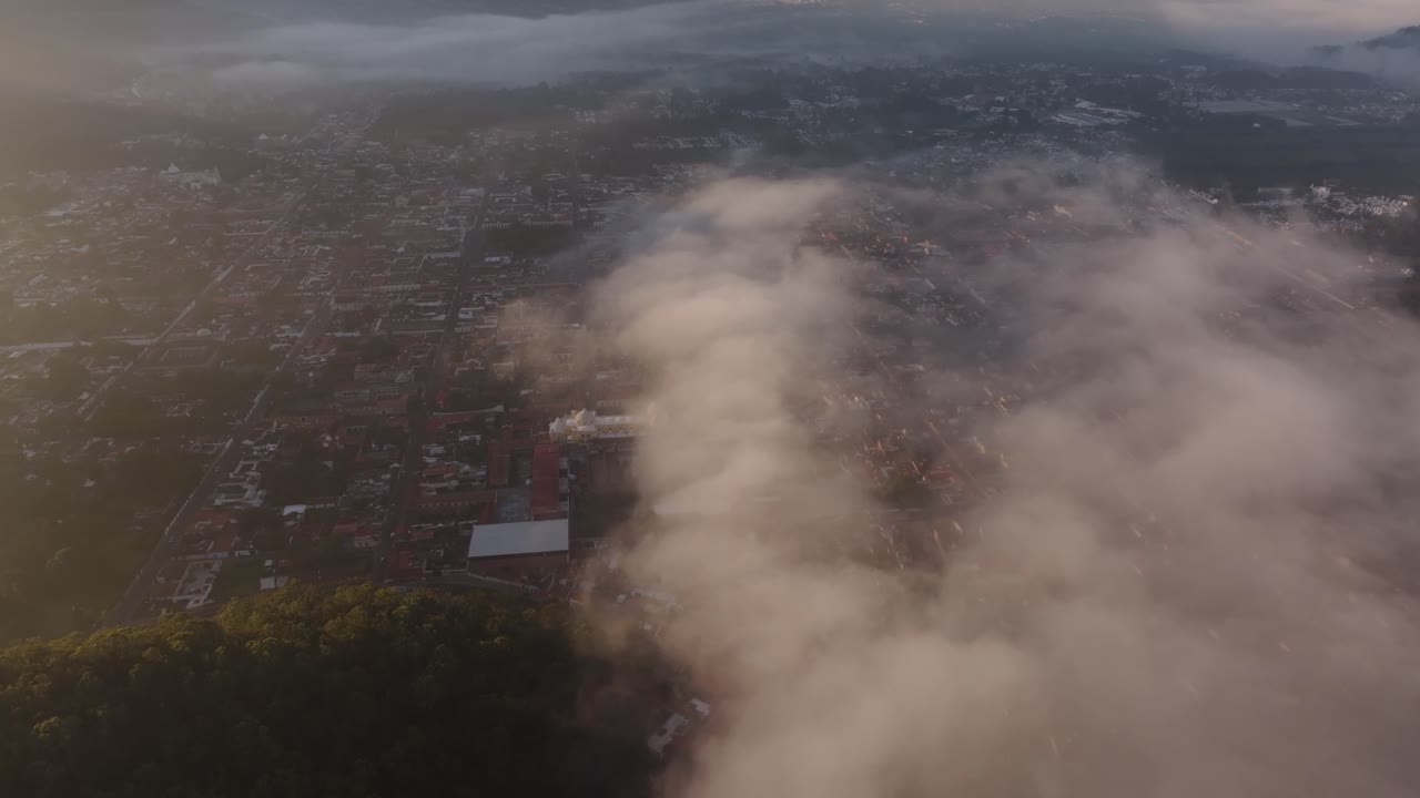 Vista aerea di Antigua Guatemala durante una tranquilla alba nebbiosa con la silhouette del Volcán Agua sullo sfondo