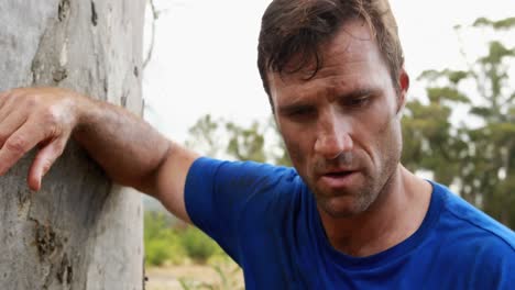 hombre en forma relajándose después del entrenamiento durante una carrera de obstáculos