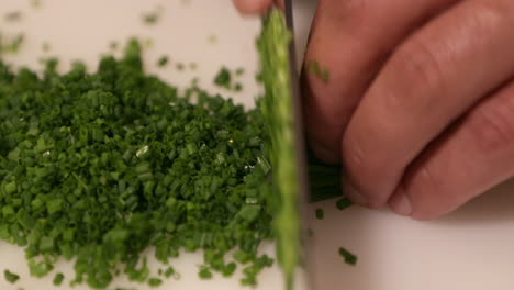 chopping fresh chives on the chopping board for sushi preparation - close up, slow motion