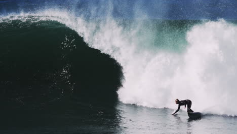 surfer charges through foamy deep barrel with wave face churning in heavy water