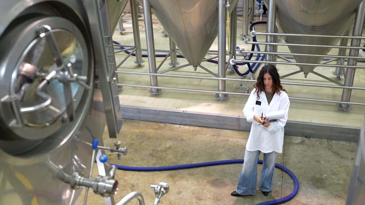 Woman Inspecting Brewery Tanks