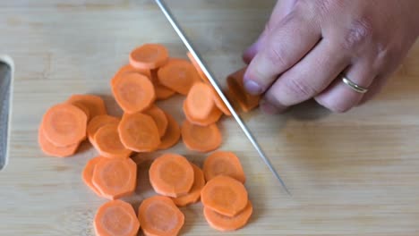 Close-up-of-Man's-hand-cutting-a-carrot.Top-view